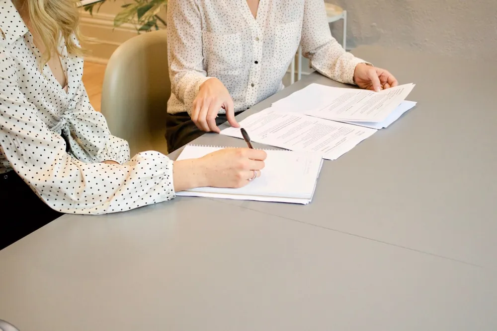 Dos personas repasando la documentación de una inversión sobre una mesa