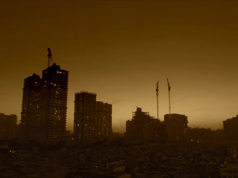 Grúas de construcción sobre el perfil de Asunción al atardecer